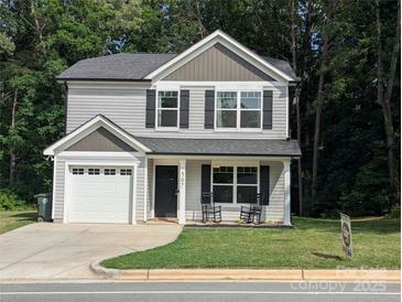 Charming two-story home with well-manicured lawn, attached garage, and inviting front porch with rocking chairs at 507 Newsome Rd, Salisbury, NC 28146