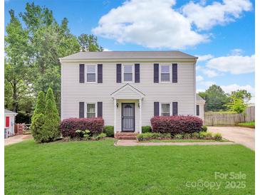 Charming two-story home featuring a well-manicured lawn and traditional design with black shutters at 10945 Wiltshire Ln, Charlotte, NC 28262