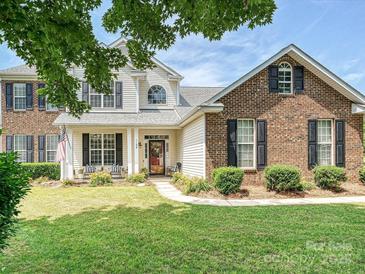 Charming two-story home with a well-manicured lawn and a welcoming front porch with black shutters at 1109 Woodwinds Dr, Waxhaw, NC 28173
