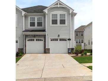 Charming townhome with a two-car garage, stone accents, and well-maintained landscaping at 13327 Savaine St, Charlotte, NC 28278