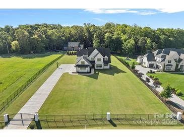 Expansive aerial view of a luxurious home with a large, well-manicured lawn and a gated entrance at 1405 Waxhaw Marvin Rd, Waxhaw, NC 28173
