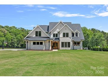 Beautiful two-story home with brick accents, complemented by a lush green lawn and mature trees at 1405 Waxhaw Marvin Rd, Waxhaw, NC 28173