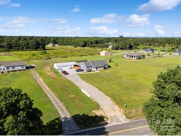 Expansive aerial view of a charming home with a long driveway, lush green lawn, and a large garage at 2268 Westbrook Rd, Edgemoor, SC 29712