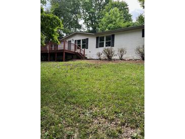 White vinyl siding home featuring a wood deck and black shutters on the front-facing windows at 4006 Hillview Dr, Shelby, NC 28152