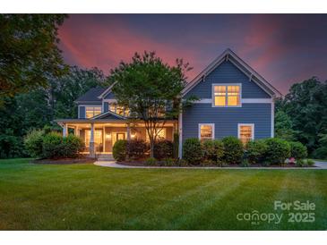 Charming two-story home with a welcoming front porch, landscaped yard, and professionally maintained lawn at 5044 Dockside Ct, Matthews, NC 28104