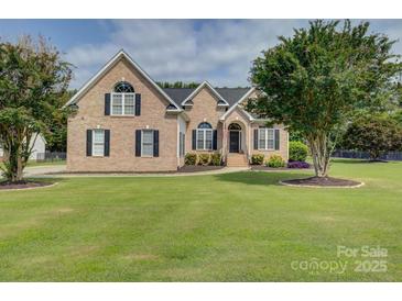 Charming brick home featuring a manicured lawn, mature trees, and classic black shutters at 736 Creekbridge Dr, Rock Hill, SC 29732