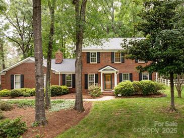 Charming brick home with black shutters and manicured landscaping at 8201 Lansford Rd, Charlotte, NC 28277