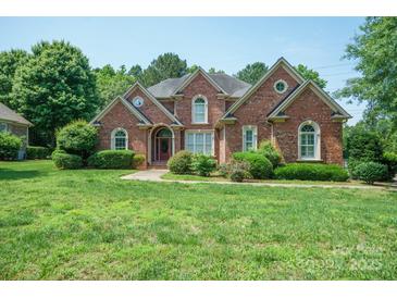 Beautiful brick home with manicured lawn, lush landscaping, and inviting curb appeal at 100 Woodwinds Dr, Mount Holly, NC 28120
