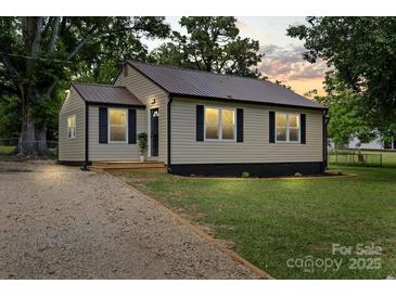 Well-maintained home with fresh landscaping and a gravel driveway at 1055 Laurel Ave, Lancaster, SC 29720