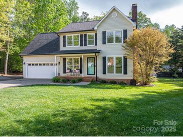 Charming two-story home featuring a well-manicured lawn, attached garage, and inviting front porch at 107 Ingonish Dr, Gastonia, NC 28056
