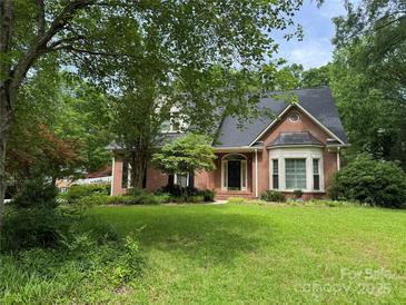 Charming brick home featuring a well-maintained lawn and mature trees providing ample shade and curb appeal at 1750 Trellis Dr, Rock Hill, SC 29732