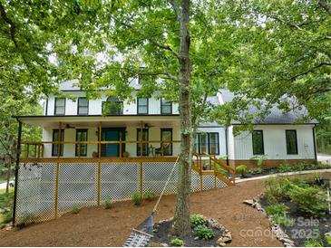 Beautiful two-story white home with black trim, large front porch, and lush landscaping at 5611 Charter Oaks Ln, York, SC 29745
