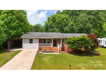 Charming single-story home featuring a cozy front porch and well-maintained lawn with mature shade trees at 613 Poplar Dr, Shelby, NC 28152
