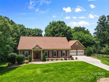 Well-maintained brick home with a manicured lawn and a two car garage at 7916 Wellston Dr, Charlotte, NC 28210