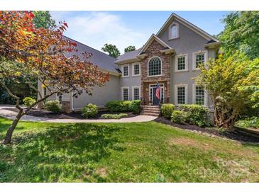 Charming two-story home with stone accents, well-manicured lawn, and lush landscaping at 2006 Sandy Pond Ln, Waxhaw, NC 28173