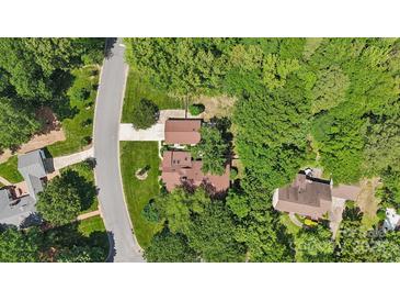 An aerial view of a brick home nestled among mature trees on a large, landscaped lot with an extended driveway at 2234 Hamilton Mill Rd, Charlotte, NC 28270