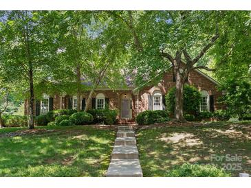 Charming brick home featuring a well-maintained lawn and mature trees providing shade and curb appeal at 2234 Hamilton Mill Rd, Charlotte, NC 28270