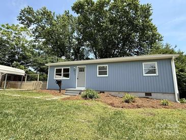 Charming one story home with blue siding, green lawn, and mature trees at 408 N Hill St, Dallas, NC 28034