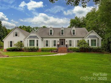 Sprawling single story home featuring well manicured yard, dormer windows, and symmetrical design elements at 4201 Quail Hunt Ln, Charlotte, NC 28226