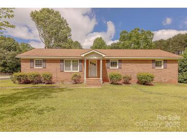 Charming brick home with a well-manicured lawn and mature landscaping at 5840 Potter Rd, Matthews, NC 28104