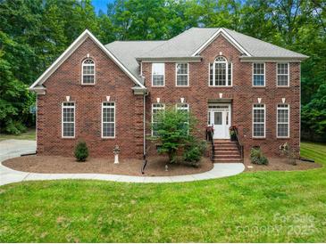 Beautiful two-story brick home with meticulously maintained landscaping and a welcoming front entrance at 763 Evans Manor Dr, Weddington, NC 28104