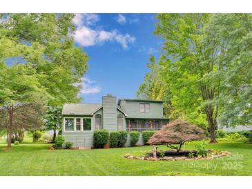 Charming home exterior features a lush green lawn, mature trees and classic architectural details at 8506 Graham Rd, Denver, NC 28037