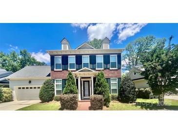 Charming two-story brick home boasts lush landscaping and dark green shutters at 1025 N Sharon Amity Rd, Charlotte, NC 28211