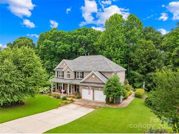 Charming two-story brick home with a well-manicured lawn, mature trees, and two-car garage at 200 Winter Flake Dr, Statesville, NC 28677