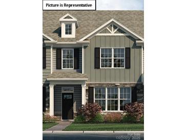 Beautifully designed townhome featuring a stone facade, black shutters, and well-maintained landscaping at 2028 Harlequin Dr, Indian Trail, NC 28079