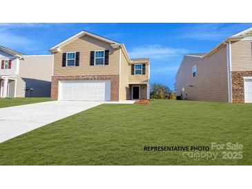 Charming two-story home with a manicured lawn, brick accents, and a two-car garage at 921 Two Brothers Ln, York, SC 29745