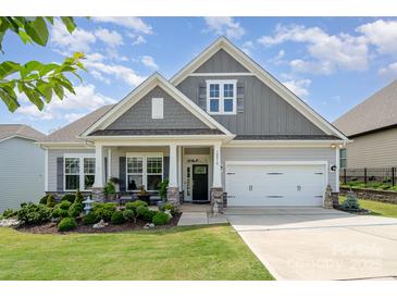 Charming single-Gathering home featuring a manicured front yard, two-car garage, and inviting front porch at 10016 St Kitts Landing Ln, Charlotte, NC 28278