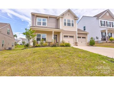 Charming two-story home featuring a two-car garage, covered porch and a well-manicured lawn at 1077 River Haven Sw Ave, Concord, NC 28025