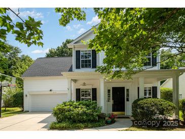 Charming two-story home features a covered front porch, lush landscaping, and an attached garage with basketball hoop at 16121 Wrights Ferry Rd, Charlotte, NC 28278