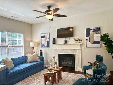Cozy living room features a fireplace, plush blue sofa, and stylish decor at 16121 Wrights Ferry Rd, Charlotte, NC 28278