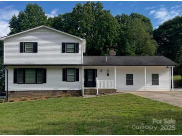 Charming two-story home with black shutters, white siding, and a well-maintained front lawn at 2412 Elizabeth Ave, Shelby, NC 28150