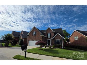 Charming two-story brick home with an attached two car garage and a well-manicured lawn at 2563 Firethorn Ct, Gastonia, NC 28056