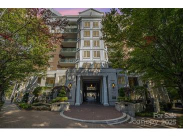 Elegant condo building entrance featuring stone columns, manicured landscaping, and a welcoming brick walkway at 300 W 5Th St # 723, Charlotte, NC 28202