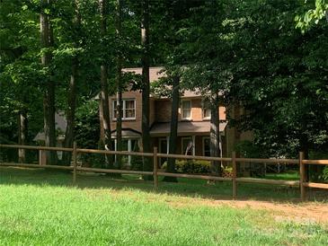 Charming two-story brick home with a well-manicured lawn and a classic wooden fence at 3513 Briarcliff Acres Dr, Lincolnton, NC 28092