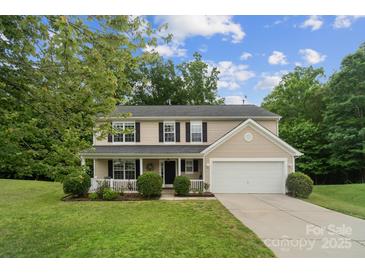 Charming two-story home with a well-manicured lawn and a cozy front porch at 4002 Paddle Wheel Ln, Indian Trail, NC 28079