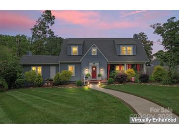Charming blue two-story home boasts a beautifully landscaped front yard and inviting red door at 509 N Oak St, Lincolnton, NC 28092
