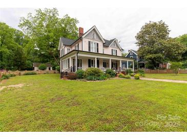 Charming two-story house boasts a large front yard with mature trees and a classic, inviting exterior at 7 Kings Mountain St, York, SC 29745