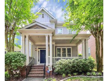 Charming home featuring a covered front porch, brick stairs, and meticulously maintained landscaping at 7023 Blakeney Greens Blvd, Charlotte, NC 28277