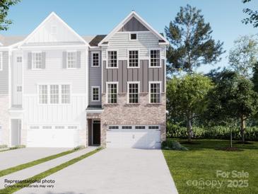 New construction townhome showing exterior with brick and siding and a two-car garage and landscaping at 1021 Bandon Dr, Waxhaw, NC 28173