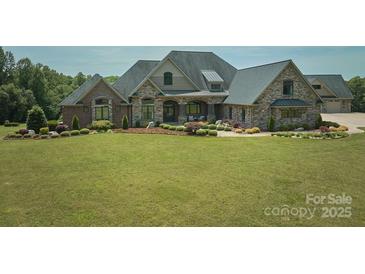 Beautiful stone and brick home featuring a lush green lawn and manicured landscaping at 109 Oak Forest Dr, Kings Mountain, NC 28086