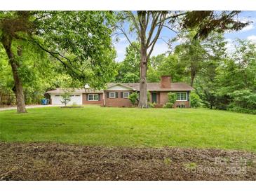 Traditional brick home featuring a manicured lawn and mature trees enhancing its curb appeal at 121 33Rd Ne Ave, Hickory, NC 28601