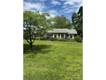 Charming single-story home with a well-maintained lawn and inviting curb appeal with mature trees and shrubs at 1512 Rutledge Ave, Charlotte, NC 28211