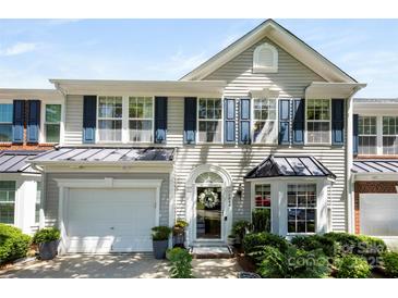 Charming two-story townhome with a light gray exterior, a black metal roof accent, and an attached garage at 1644 Backcreek Ln, Gastonia, NC 28054