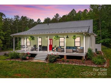Inviting home boasts a charming front porch with comfortable seating, hanging plants, and manicured landscaping at 213 Genesis Pl, Cleveland, NC 27013