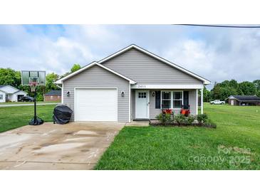 Charming single-story home featuring a one-car garage, grey siding, and well-maintained front lawn at 2411 28Th Ne St, Hickory, NC 28601