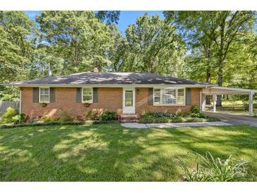 Charming single-story brick home featuring a well-manicured front yard and covered carport at 2522 Doster Rd, Monroe, NC 28112